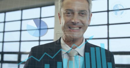 Photo for Image of statistics and data processing over caucasian businessman smiling in office. Global business, connections, computing and data processing concept digitally generated image. - Royalty Free Image