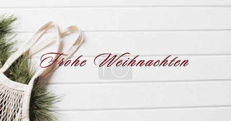 Photo for Frohe weihnachten text in red over shopping bag with christmas bracnhes on white wood background. Christmas, decorations, tradition, german, greetings and celebration digitally generated image. - Royalty Free Image