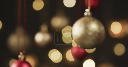 Foto de Adornos rojos y dorados de Navidad cuelgan con gracia, con espacio para copias. Decoraciones festivas evocan el espíritu navideño en un ambiente cálido y acogedor. - Imagen libre de derechos
