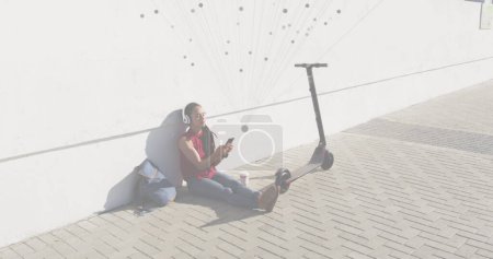 Téléchargez les photos : Image d'un réseau de connexions sur une femme écoutant des musci à l'aide d'un smartphone. Interface numérique concept mondial de sport et de performance image générée numériquement. - en image libre de droit