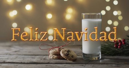 Photo for Feliz navidad text in orange over christmas cookies and milk and bokeh lights background. Christmas, tradition, greetings and celebration digitally generated image. - Royalty Free Image