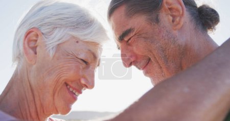 Caucasian couple enjoying a sunny outdoor setting, with copy space. Their warm smiles and close proximity suggest a moment of shared happiness.