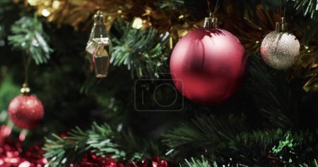 Téléchargez les photos : Les décorations de Noël ornent un arbre de fête. Les ornements scintillent de joie de vacances, reflétant la chaleur de la saison. - en image libre de droit