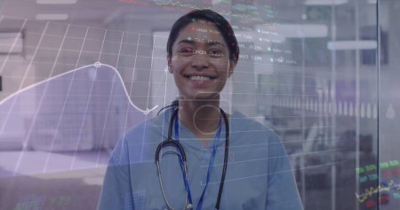 Foto de Imagen de la interfaz digital que muestra estadísticas con el médico femenino mirando a la cámara y sonriendo. Salud y protección durante coronavirus covid 19 pandemia, imagen generada digitalmente - Imagen libre de derechos