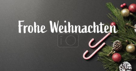 Foto de Frohe weihnachten texto con bastones de caramelo, rama de árbol de Navidad y bolas sobre fondo gris. Navidad, decoraciones, alemán, tradición, saludos y celebración de imagen generada digitalmente. - Imagen libre de derechos