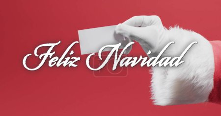 Photo for Feliz navidad text in white over hand of father christmas holding blank card on red background. Christmas, tradition, greetings and celebration digitally generated image. - Royalty Free Image