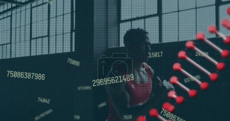Téléchargez les photos : Image d'une souche d'ADN filant sur un homme faisant du jogging dans un bâtiment abandonné. Interface numérique concept mondial de sport et de performance image générée numériquement. - en image libre de droit