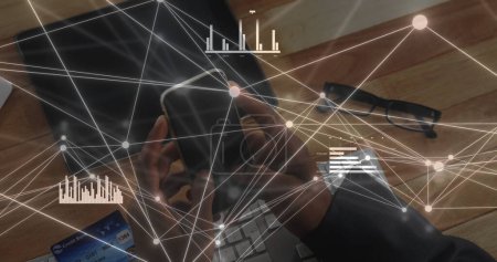 Foto de Hombre de negocios afroamericano analiza los datos en un ordenador portátil, con espacio para copias. Gráficos y gráficos superponen la imagen, indicando un enfoque en analítica y estrategia en un entorno de oficina. - Imagen libre de derechos