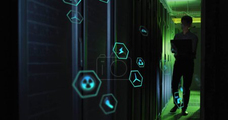 Photo for Image of tech icons in hexagones over asian man working in server room. network, programming, computers and technology concept digitally generated image. - Royalty Free Image