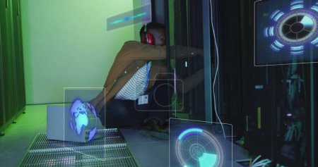Foto de Imagen del procesamiento de datos en pantallas sobre el hombre afroamericano que trabaja en la sala de servidores. concepto de red, programación, ordenadores y tecnología - Imagen libre de derechos