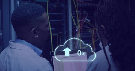 Photo for Image of cloud with uploading over african american man working on laptop in server room. network, programming, computers and technology concept digitally generated image. - Royalty Free Image