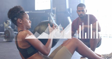 Photo for Image of interface over african american male instructor and woman using medicine ball at gym. Fitness, exercise, strength, data, digital interface and technology digitally generated image. - Royalty Free Image