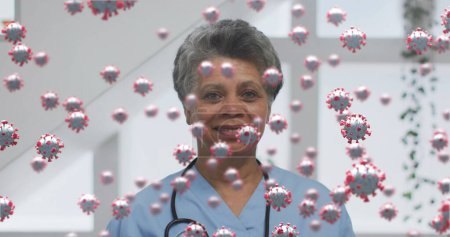Foto de Imagen de 19 células covid sobre doctora sonriente con estetoscopio. mundial covid 19 pandemia, salud y medicina concepto de imagen generada digitalmente. - Imagen libre de derechos