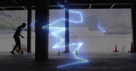 Digital composite image of blue thunderstorm effect against man practicing soccer. sports and fitness concept