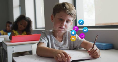 Téléchargez les photos : Image d'icônes de l'école sur un écolier caucasien travaillant au bureau en classe. École, éducation, enfance et apprentissage, image générée numériquement. - en image libre de droit