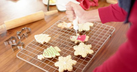 Photo for Person decorating cookies at home, with copy space. A home baking scene with a focus on cookie decoration and festive preparation. - Royalty Free Image