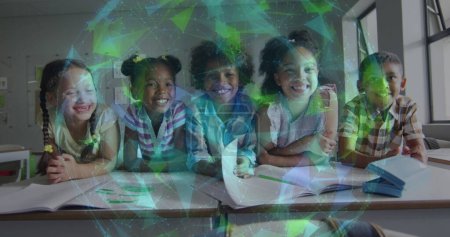 Téléchargez les photos : Image d'un réseau lumineux sur des écoliers souriants et variés au bureau dans la salle de classe. Communication, amitié, école, éducation, enfance et apprentissage, image générée numériquement. - en image libre de droit