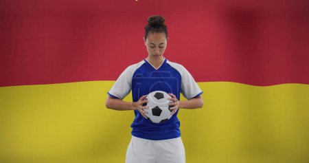Bild einer zweirassigen Fußballerin über der Nationalflagge. Globaler Sport, Patriotismus und digitales Schnittstellenkonzept digital generiertes Image.
