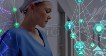 Téléchargez les photos : Globe d'icônes médicales contre les travailleuses de la santé caucasiennes utilisant une tablette numérique à l'hôpital. concept de technologie de santé et de recherche médicale - en image libre de droit