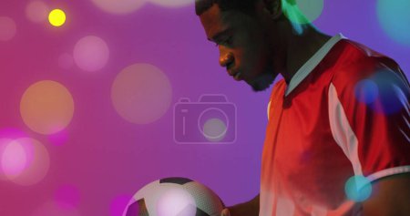 Bild eines afrikanisch-amerikanischen männlichen Fußballspielers über Flecken. Globaler Sport und digitales Schnittstellenkonzept digital generiertes Image.