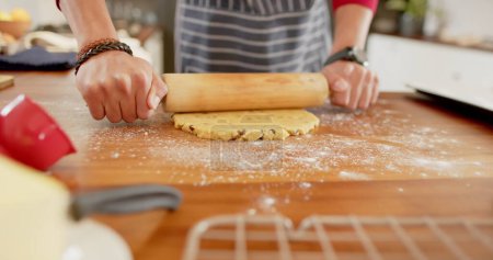 Foto de La persona despliega la masa en el mostrador de la cocina. Inicio escena de hornear muestra las manos preparando la pastelería con un rodillo. - Imagen libre de derechos