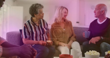 Téléchargez les photos : Groupe diversifié de personnes âgées parlant avec le thé à la maison - en image libre de droit