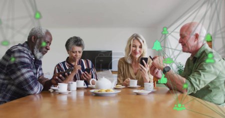 Photo for Image of media icons over diverse group of seniors talking with tea - Royalty Free Image