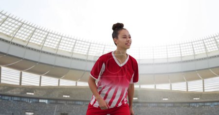 Bild einer zweirassigen Fußballerin über dem Stadion. Globaler Sport, Patriotismus und digitales Schnittstellenkonzept digital generiertes Image.