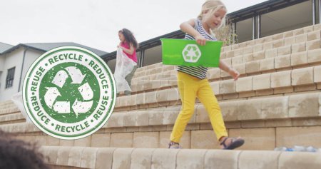 Foto de Imagen del logotipo del reciclaje en diversas colegialas que recogen residuos plásticos fuera de la escuela. Escuela, ecología, reciclaje, educación, infancia y aprendizaje, imagen generada digitalmente. - Imagen libre de derechos