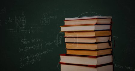 Foto de Compuesto digital de un montón de libros, mientras que las ecuaciones matemáticas y gráficos escritos en un fondo verde se mueve - Imagen libre de derechos