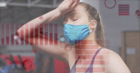 Foto de Coronavirus procesamiento de datos estadísticos contra la mujer que usa máscara tomando un descanso en el gimnasio. coronavirus covid-19 concepto pandémico - Imagen libre de derechos