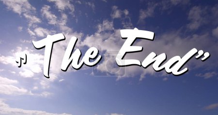 Téléchargez les photos : Image numérique d'un panneau "The End" blanc apparaissant à l'écran avec un fond de ciel nuageux pendant la journée - en image libre de droit