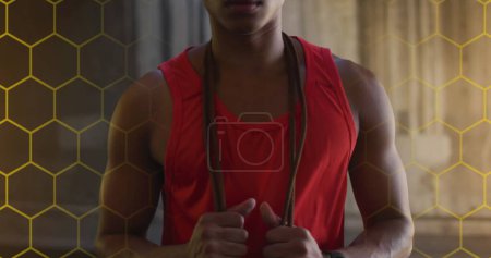 Téléchargez les photos : Image d'une grille hexagonale et de lumières sur un athlète afro-américain tenant une corde à sauter. sport, réalisation et concept de technologie de la communication - en image libre de droit