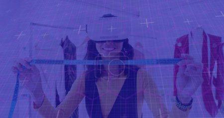 Téléchargez les photos : Des sentiers lumineux sur le réseau grille contre la créatrice de mode féminine portant un casque vr au studio. interface informatique et concept technologique - en image libre de droit