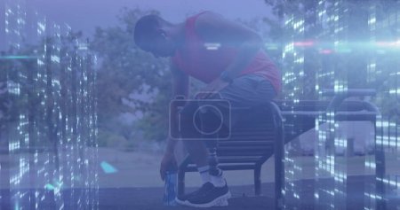 Téléchargez les photos : Image de serveurs informatiques traitant des données sur un athlète masculin avec une jambe prothétique reposant à l'extérieur. - en image libre de droit