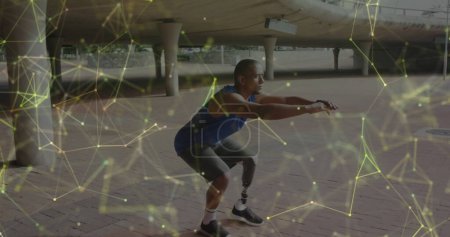 Téléchargez les photos : Image du réseau de communication jaune sur l'athlète masculin avec la jambe prothétique faisant de l'exercice à l'extérieur. - en image libre de droit