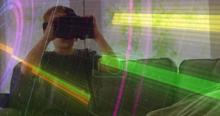 Photo for Light trails over scope scanning against caucasian boy wearing vr headset at home. computer interface and technology concept - Royalty Free Image