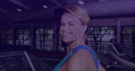 Photo for Image of glowing interface processing data over smiling woman on treadmill. sport, fitness and technology concept, digitally generated image. - Royalty Free Image