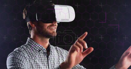 Hexagonal shapes and light trails over caucasian man wearing vr headset against black background.