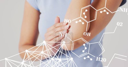 Image of chemical structures over biracial woman putting cream on her arm. Global medicine and digital interface concept digitally generated image.