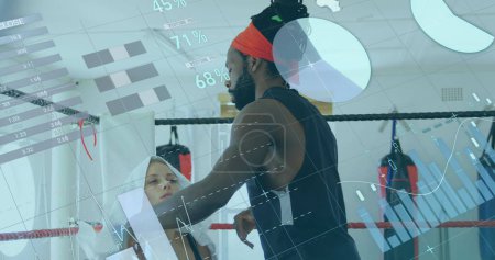 Image of digital interface with statistics and data processing over female boxer with male coach putting towel on her head. Global computer network technology concept digitally generated image.