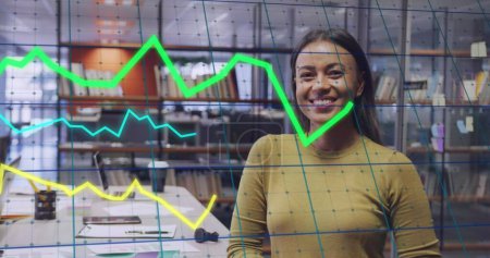 Image of data processing over biracial businesswoman smiling in office. Global business and digital interface concept digitally generated image.