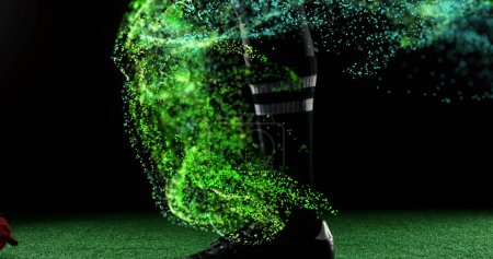 Bild von glühenden grünen Teilchen, die sich über Rugbyspieler bewegen, die Ball kicken. Sport- und Wettkampfkonzept, digital generiertes Image.