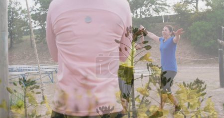 Bild von Pflanzen über verschiedenen Frauen beim Hindernislauf High Fiving. Globales Sport-, Gesundheits-, Fitness- und digitales Schnittstellenkonzept digital generiertes Image.