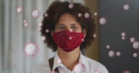 Bild von Viruszellen über einem Mann mit Gesichtsmaske. Social Media und Kommunikationsschnittstelle während Covid 19 Pandemiekonzept digital generiertes Bild.