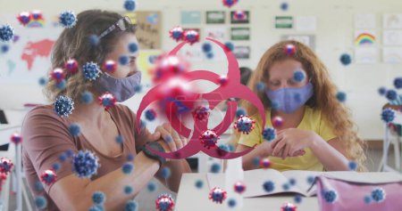 Bild des Biohazard Zeichen covid 19 Zellen über weibliche Lehrerin und Schülerin in Gesichtsmasken. Gesundheitsfürsorge und Schutz während der Coronavirus-Covid 19 Pandemie, digital generiert vide