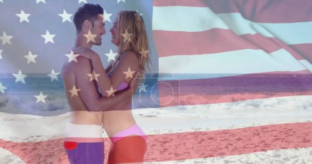 Téléchargez les photos : Image du drapeau des Etats-Unis sur le couple caucasien sur la plage en été. Usa, diversité américaine, drapeau national et patriotisme concept image générée numériquement. - en image libre de droit