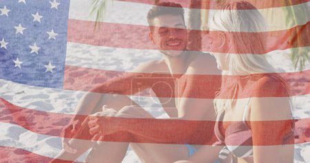 Téléchargez les photos : Image du drapeau américain agitant sur un couple souriant amoureux sur la plage. usa patriotisme et démocratie concept image générée numériquement. - en image libre de droit