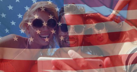 Téléchargez les photos : Image de drapeau des Etats-Unis sur divers amis sur la plage en été. Usa, diversité américaine, drapeau national et patriotisme concept image générée numériquement. - en image libre de droit