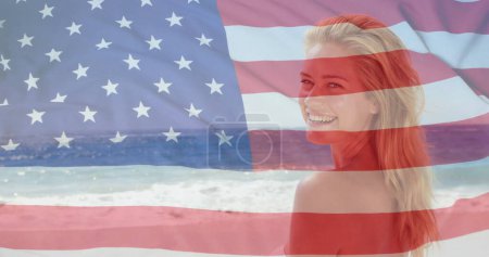 Foto de Imagen de la bandera de usa sobre mujer caucásica en la playa en verano. - Imagen libre de derechos